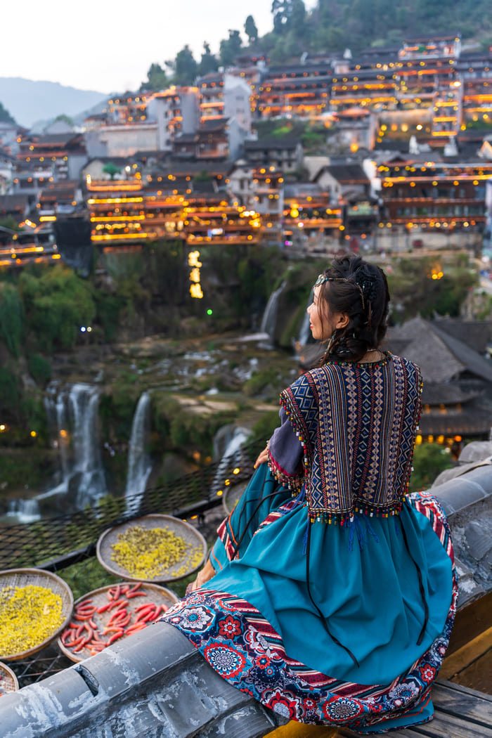 Mujer cocinando y observando la ciudad de lijang